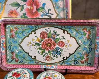 This lot features a collection of four (4) pieces of Daher Decorative Ware including two trays & two tin boxes. The largest tray measures, 13.75” H x 13.75” W. Daher’s most recognizable tins are decorated with detailed floral and geometric designs, rich in color, and often including metallic inks and raised or embossed relief. In addition to tin boxes, Daher also produced trays, plates, plaques, and other assorted tin ware for practical and decorative use.