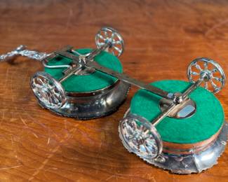 This lot features an antique Victorian silver plated wine coaster trolley made in Japan along with a sterling silver wine coaster by Frank Whiting & Co.