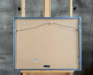 This lot features an original mixed media painting, housed in silver metal frame and depicts a sunlit walkway with geometric shadows. Signed lower left and measures in frame, 21” H x 27” W.