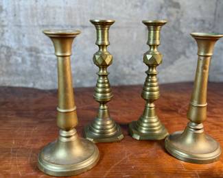 This lot features a collection of six (6) antique brass candlesticks. Three matching pairs with the tallest measuring, 9.5” H.