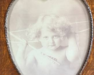 “Cupid Awake”, a rather famous portrait taken by master photographer, M.B. Parkinson held in an incredible quarter-sawn oak frame. This photo measures in frame, 24” H x 20” W. Morris Burke Parkinson was an American photographer, best known for his “Cupid Awake” and “Cupid Asleep” photos, which were supplied in frames produced by the Ohio Art Company circa 1912. Parkinson was born around Buffalo, New York, but moved with his family to Oshkosh, Wisconsin soon after.
