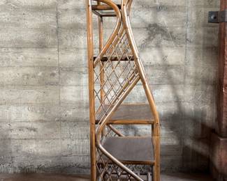 This lot features a vintage rattan shelving unit with two glass shelves on the top two tiers. This unit measures, 71.5” H x 29.5” W x 19.5” D.