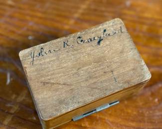 This lot features a collection of inkwells and accessories. One appears to be handmade out of wood and signed underneath by John R Craighead.