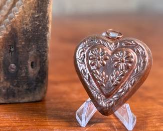 This lot features an antique wooden heart mold and a copper heart!