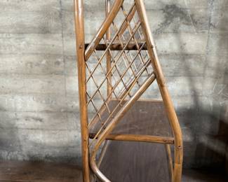 This lot features a vintage rattan shelving unit with two glass shelves on the top two tiers. This unit measures, 71.5” H x 29.5” W x 19.5” D.