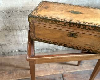This lot features an incredible 19th century Italian travel desk on a wooden stand. The travel desk is removable and features numerous drawers and compartments inside. This piece measures (on the stand), 26” H x 20” W x 11” D.