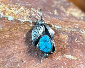 This lot features a sterling silver pendant with a turquoise stone, signed by listed artist, David F. Garcia. This pendant measures, 1.25” H and has a total approx. weight of 3.50 grams.