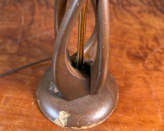 This lot features a mid-century modern sculptural table lamp, made of walnut and brass. Minor wear throughout as shown in photos and light turns on periodically (will need to some servicing or love). This lamp measures, 38” H x 7” W x 7” D.