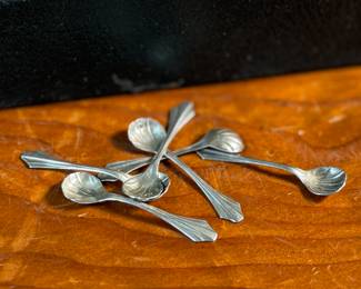 This lot features an antique set of six (6) salt cellars, accompanied by six (6) sterling silver spoons with a total approx. weight of 10.22 grams.