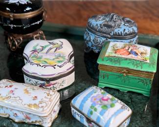 This lot features a large collection of antique trinket boxes that are primarily porcelain. Many of them contain maker marks and are held on a vintage green tray that is included.