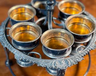 This lot features an antique silver-plated Victorian egg cruet set with six egg cups. This cruet measures, 9” H x 7.5” W x 7.5” D.