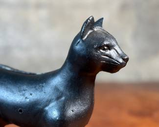 This lot features a vintage cast iron “cat” bank that measures, 7.5” H x 9” W x 3” D.