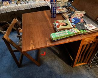 A very cool mid-century, modern table and chairs set. The table folds down, and the chairs are stored inside the table.