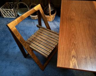 A very cool mid-century, modern table and chairs set. The table folds down, and the chairs are stored inside the table.