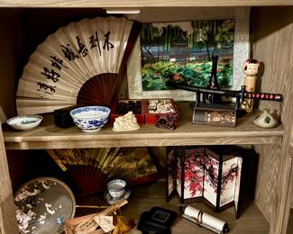 Authentic Chinese décor, artwork, and handcrafted cultural pieces. Many items are traditional arts—wood carving, porcelain, embroidered silk, and painted fans.
✨ Decorative Fans & Art
• hand-painted calligraphy fan
• Embroidered silk art scene with lotus pond and pavilion
• printed scroll and miniature folding screen featuring cherry blossoms
✨ Porcelain & Ceramics
• Blue-and-white porcelain bowl and porcelain tea cup set
• Miniature dish and decorative stone piece
✨ Handcrafted Items
• Carved wooden figurine pieces, boat and dragon sculptures
• Boxed wooden chopstick set
• lacquer display boxes
✨ Traditional Collectibles
• Wooden kokeshi-style doll
• Decorative miniature katana display
• Inkstone or brush washer