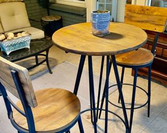 industrial-style bar table and stool set featuring a round wooden top and hairpin metal legs