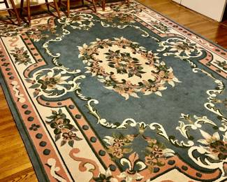 Royal Aubusson-inspired area rug, featuring a central floral medallion and a detailed border in a color palette of teal, pink, beige, and green