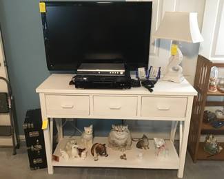 Table with drawers, TV, seahorse lamp, etc.