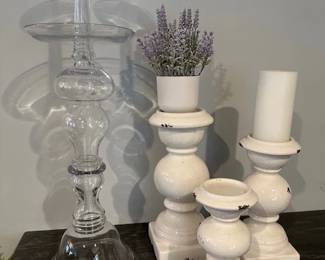 Distressed white ceramic pillar candle holders and clear glass hurricane vase and a pair of clear glass candle holders.