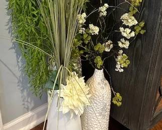 White ceramic vases with faux greenery and flowers.