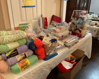 Full craft table, with scrapbooking, needle point, felt, stickers, fun kid crafts, yarn, ribbon, lots of lace, sewing items, containers of all kinds of charms and whatnot.