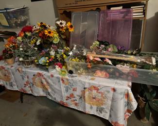 Two large bins full of flowers plus some vases and flower arrangements.
