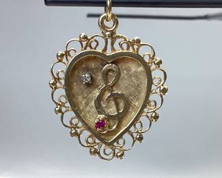 14K HEART PENDANT WITH DIAMOND AND RUBY THIS 14K HEART PENDANT FEATURES A TREBLE CLEF NOTE WITH DIAMOND AND RUBY ACCENT. WEIGHT IS 3.82 GRAMS