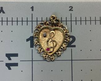 14K HEART PENDANT WITH DIAMOND AND RUBY THIS 14K HEART PENDANT FEATURES A TREBLE CLEF NOTE WITH DIAMOND AND RUBY ACCENT. WEIGHT IS 3.82 GRAMS