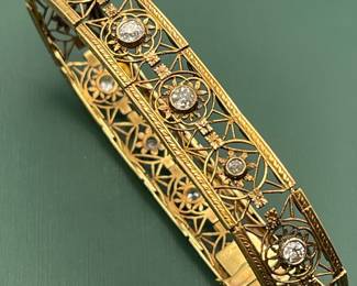 Antique 18kt yellow gold filigree bracelet featuring approximately 1.5 carats of diamonds and a box clasp adorned with a smaller diamond.