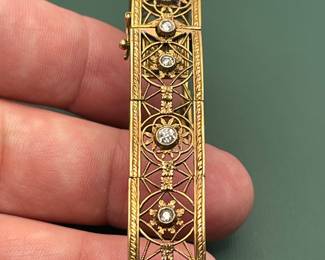 Antique 18kt yellow gold filigree bracelet featuring approximately 1.5 carats of diamonds and a box clasp adorned with a smaller diamond.