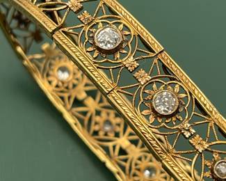 Antique 18kt yellow gold filigree bracelet featuring approximately 1.5 carats of diamonds and a box clasp adorned with a smaller diamond.