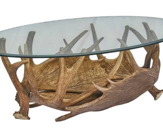 Ranch style coffee table with glass top on a base constructed of faux moose antlers