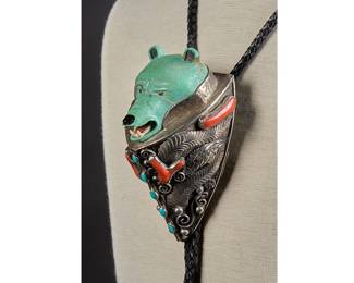 Vintage Native American sterling silver bear's head bolo tie, with hand-carved turquoise bear's head, inlaid turquoise and coral details, geometric and foliate motifs, circa 1980s