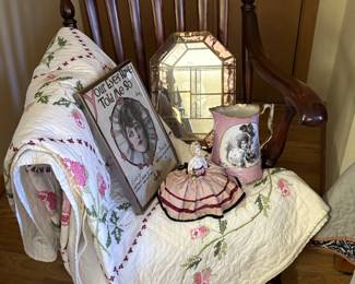 Lovely antique rocker with carving.  Sweet hand-stitched quilt that has been painstakingly cross stitched with roses.  There is also a nice pincushion doll in this picture with the other interesting items.