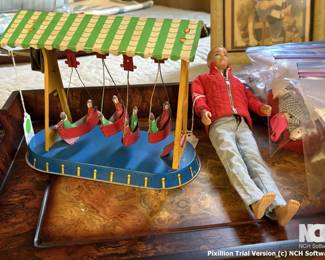 This is a picture of a tin litho canoe that winds up and they swing in the air above the water.  On the right is a vintage Ken doll...sorry he is barefoot and unprepared for winter.  You should puchase him so he doesn't get frostbite.
