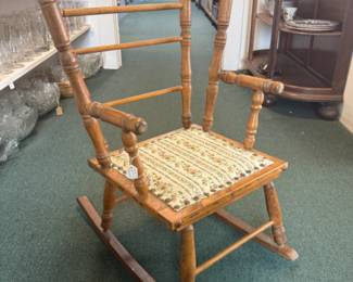 Small child's wooden rocking chair with a cute fabric bottom