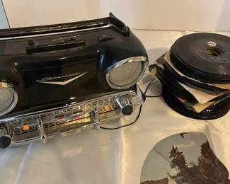 An old Randys 57 Chevy radio some old 45 records and a old radio and television sales and servicefan
