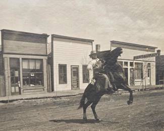 Early photograph Cowgirl named Spaugh on bucking horse in Lusk Wyoming