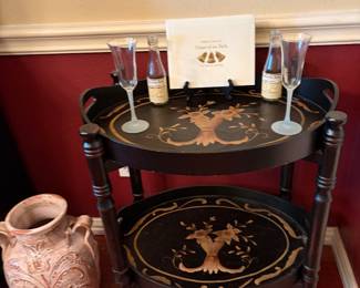 A black and gold two tier toleware tray table