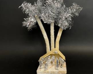 Kitschy vintage nativity scene with tinsel palm trees