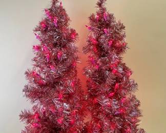 Two pink tinsel lit Christmas trees, tabletop size