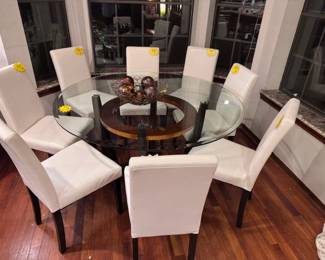 8 white high back chairs and a glass dining/kitchen glass top table