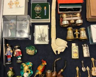 Showcase with collectible eggs from Fenton and Swarovski, enamel trinket boxes, vintage R Mandle balalaika brooches, opera glasses, and pipes