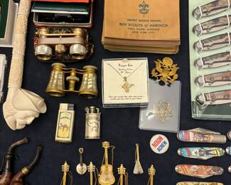Pipes, vintage R Mandle balalaika brooches, opera glasses, Boy Scout merit badge books from 1929, Camel lighters, and other novelties