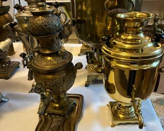 Multiple samovars in mixed metals, from polished brass to darker finishes, offering a rich variety of textures and forms.