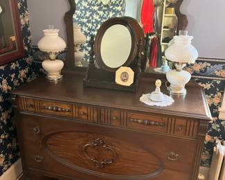 Antique dresser and mirror with ornate carvings and brass hardware.