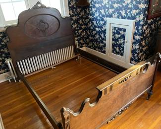 Antique full-size bed with ornate headboard.