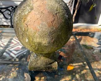 Several aged outdoor terra-cotta balls with moss, small, medium, and large