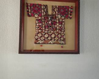 Child's tunic in shadow box frame.