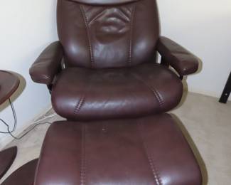 Burgundy leather push back recliner and footstool.